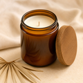 Amber glass coconut soy candle on a cream surface