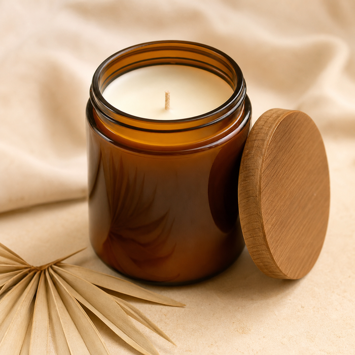 Amber glass coconut soy candle on a cream surface